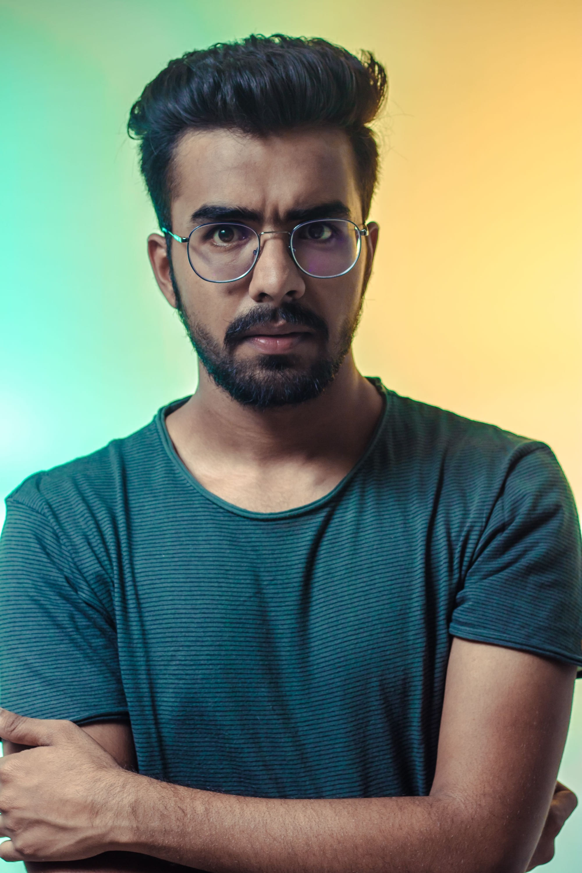 A man in a teal T-shirt with his arms folded